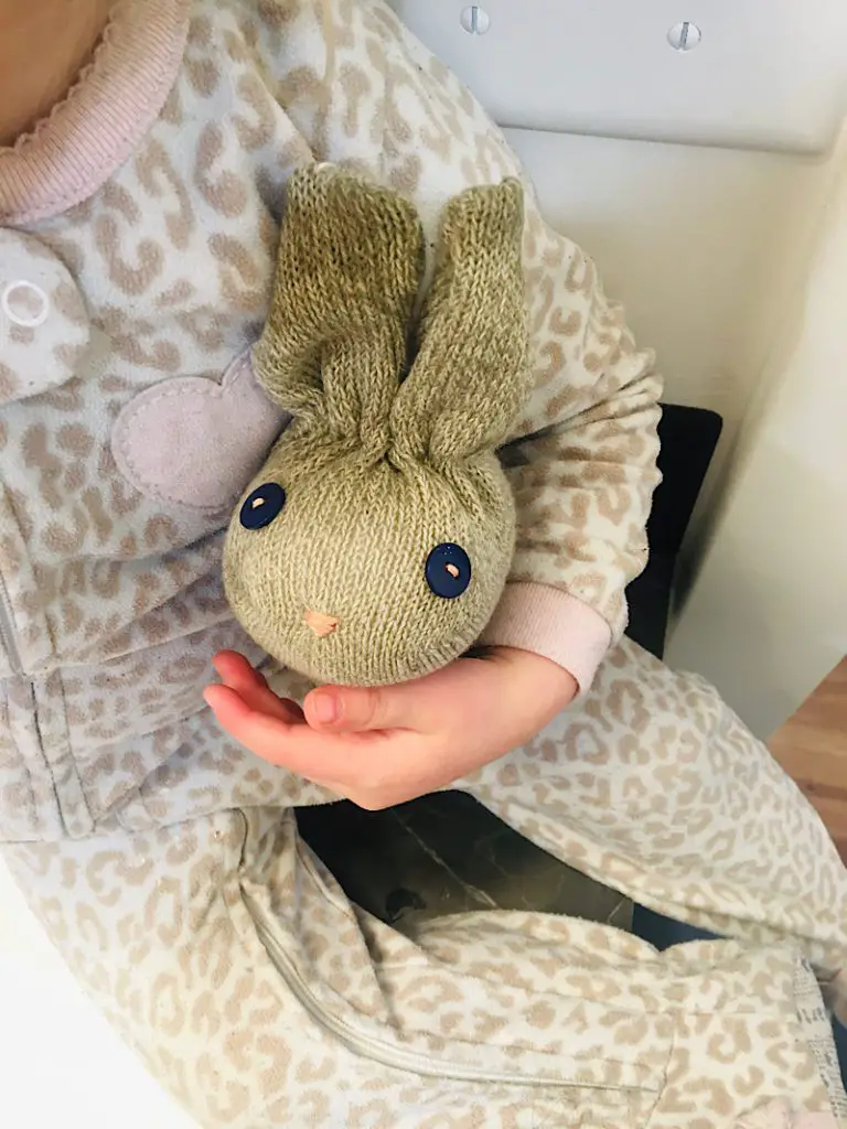 toddler holding a stuffed animal sock bunny