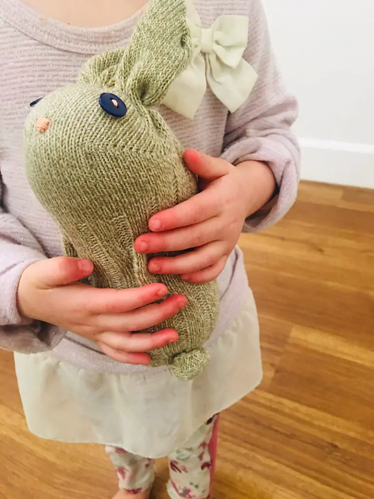 child's hands holding sock bunny
