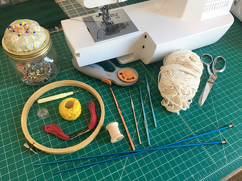 needlearts tools, sewing machine, embroidery hoop. knitting needles, crochet hooks, pins, yarn, floss, sea, ripper, scissors