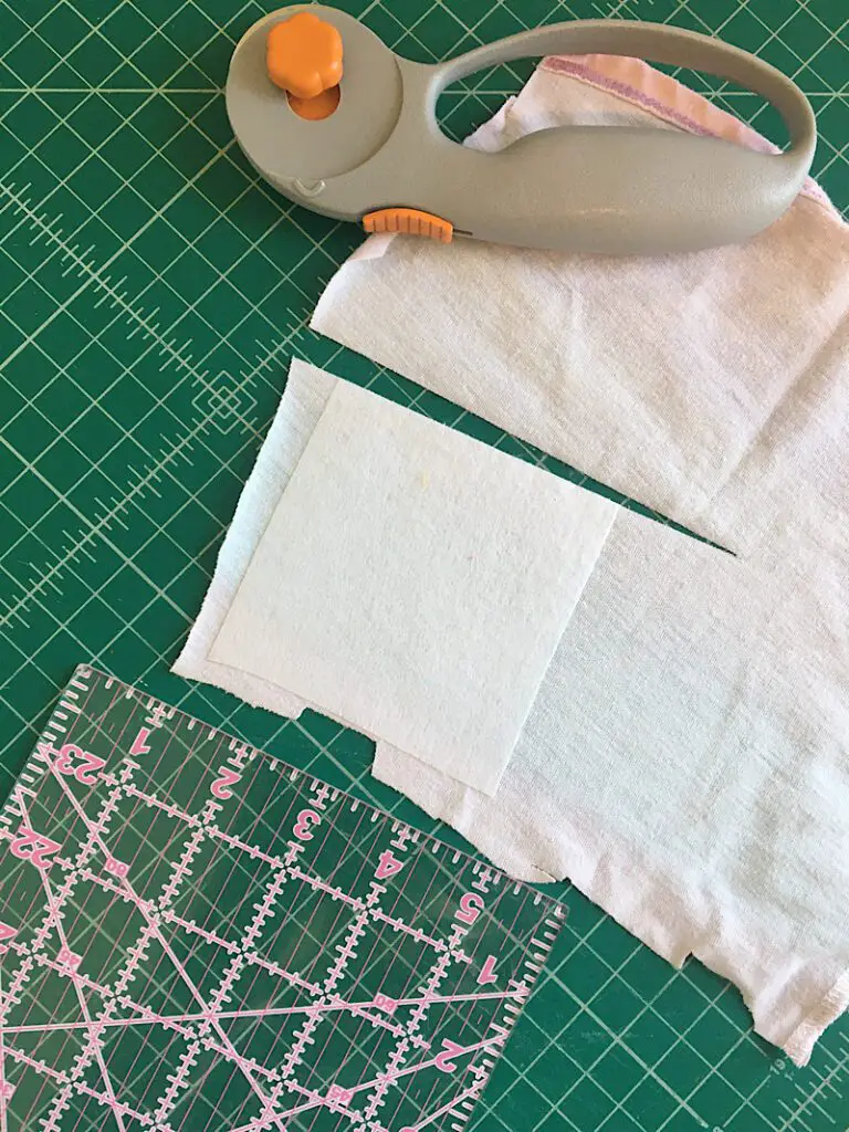 cut squares out of baby clothesa