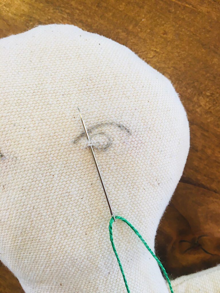 embroidering a satin stitch on a dolls eye