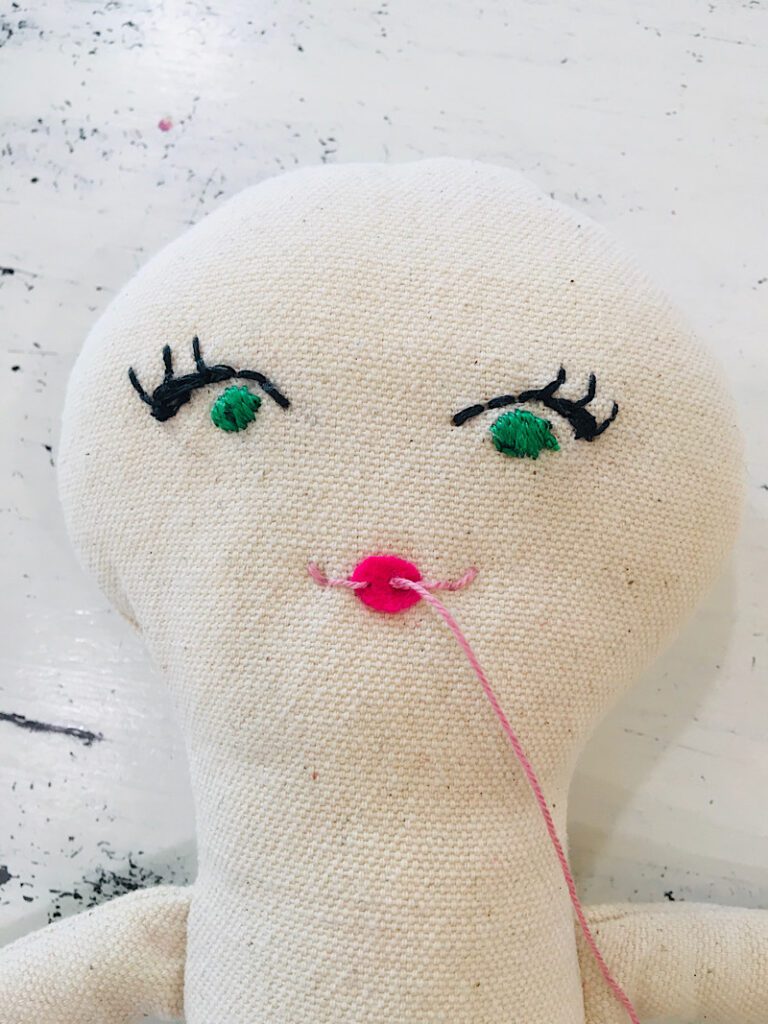 embroidering doll lips with pink floss