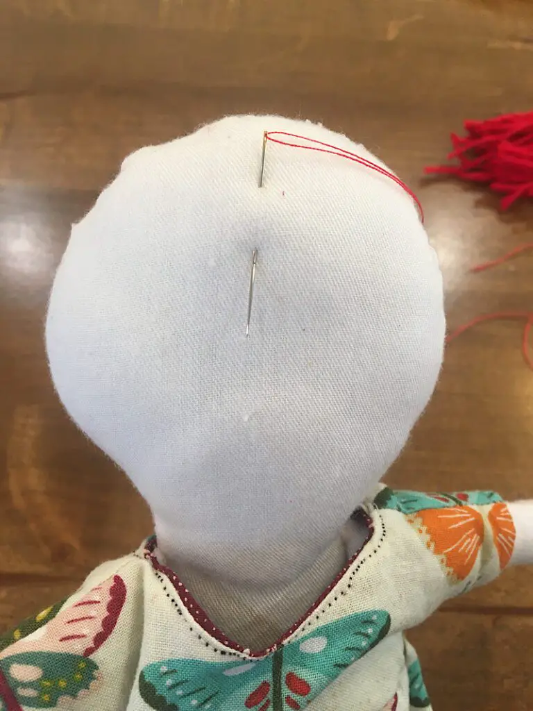 needle entering into cloth doll head