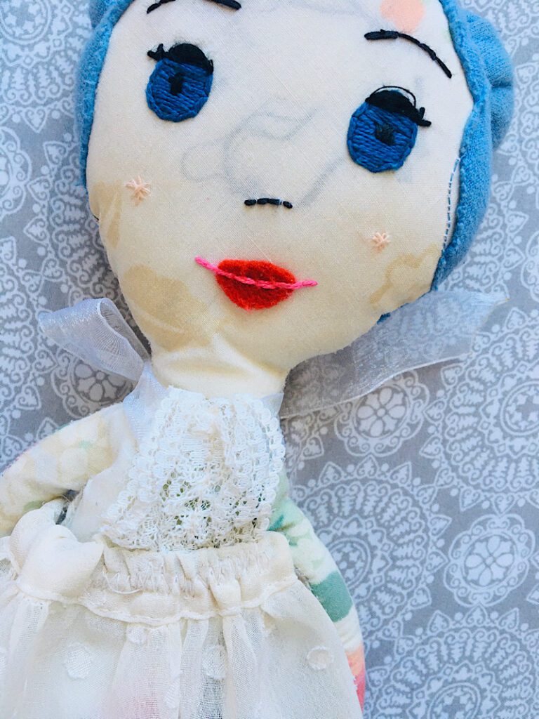 Cloth doll with large felt lips and mouth embroidery