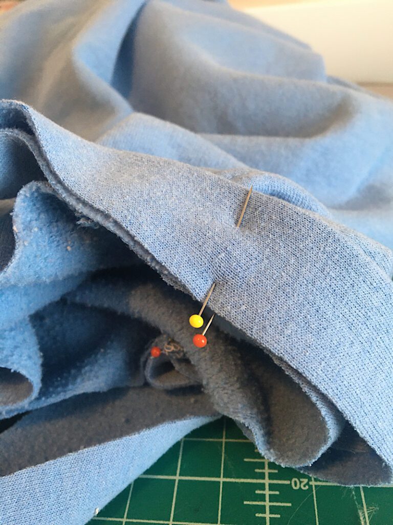 aligning the pins on the neckband to the pins on the crew neckline