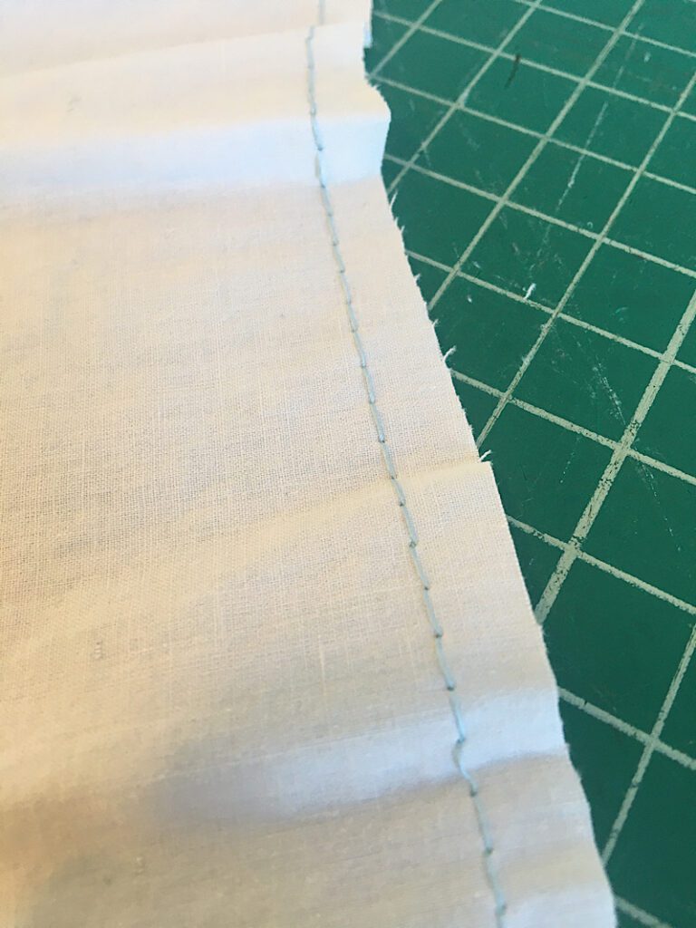 a basting stitch sewn at the top of the skirt