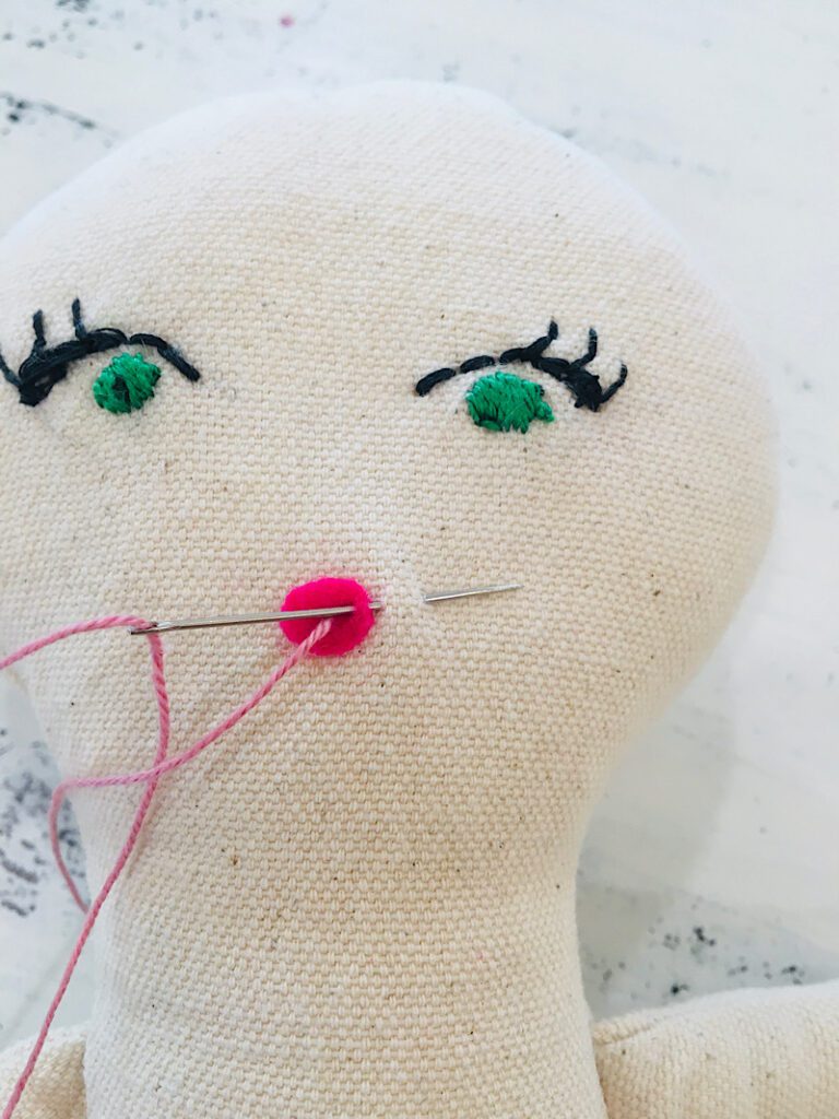 embroidering the dolls smile
