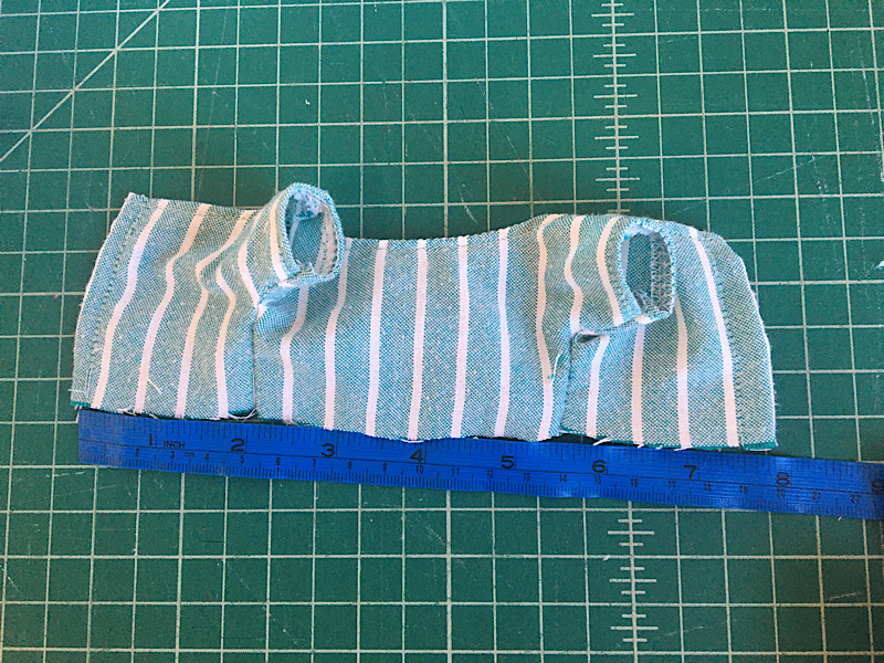 measuring the bottom edge of the bodice with a blue tape measure