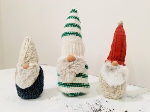 three christmas gnomes made from sweaters on table