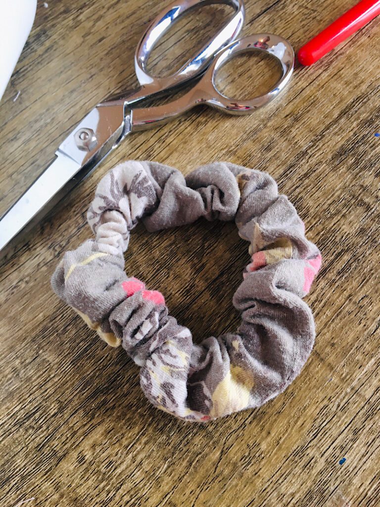Finished scrunchie with scissors and seam ripper on table