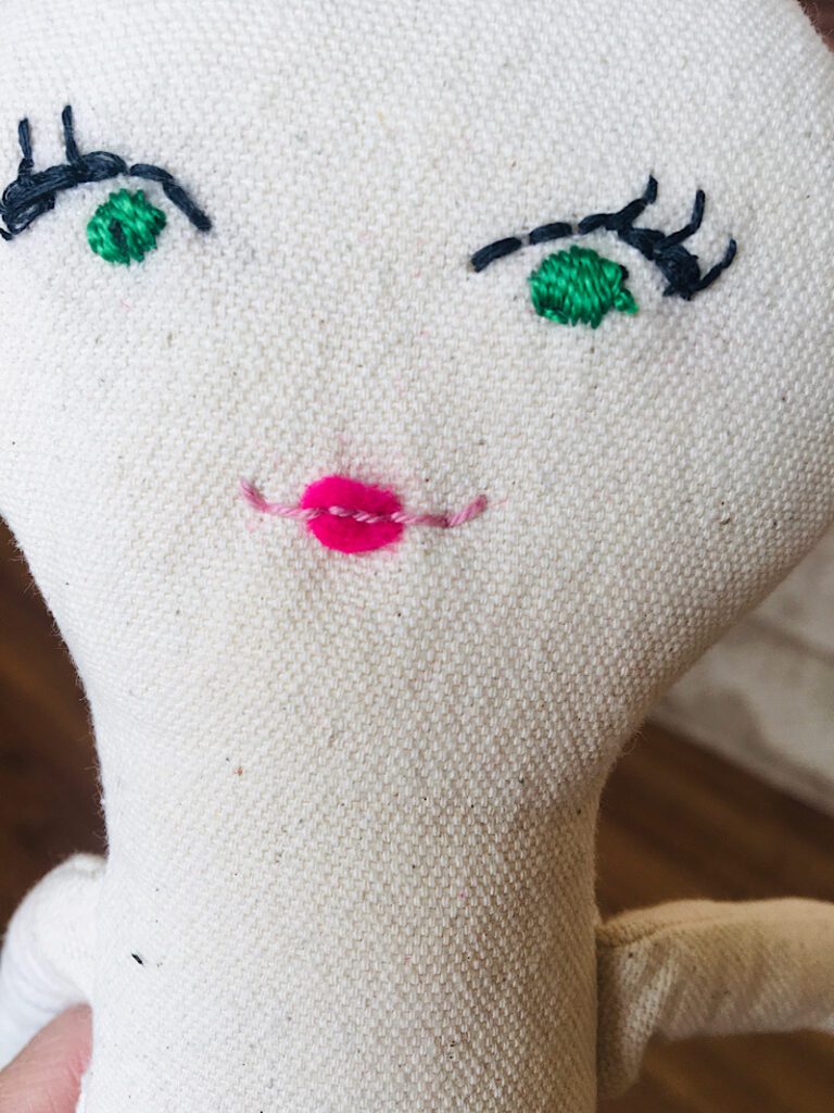 Finished embroidered lips on a cloth doll