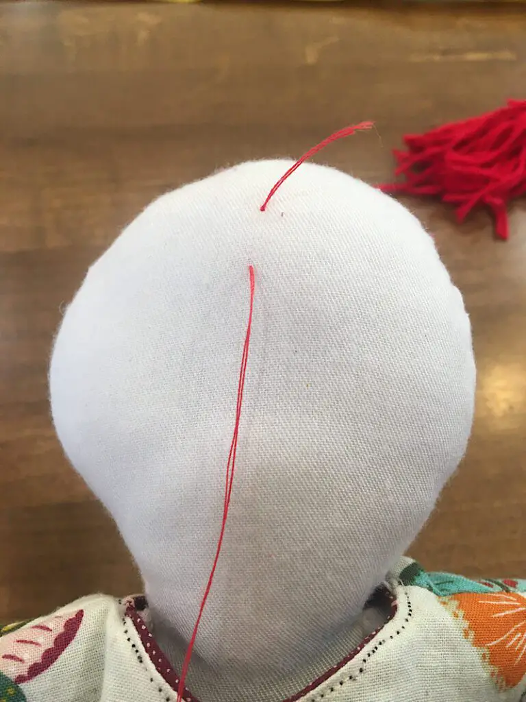 exit the needle with thread on doll's hairline