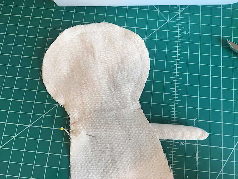 pin the arm between the layers of the cloth doll body