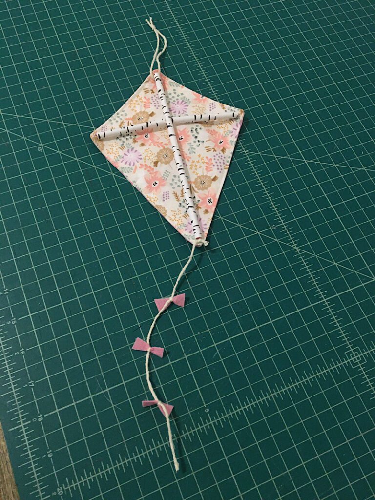 completed pink decorative fabric kite on table