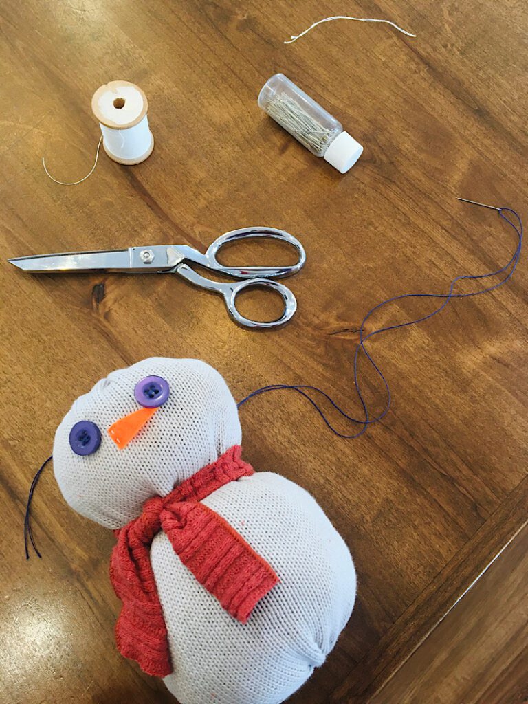 sew the button eyes on snowman