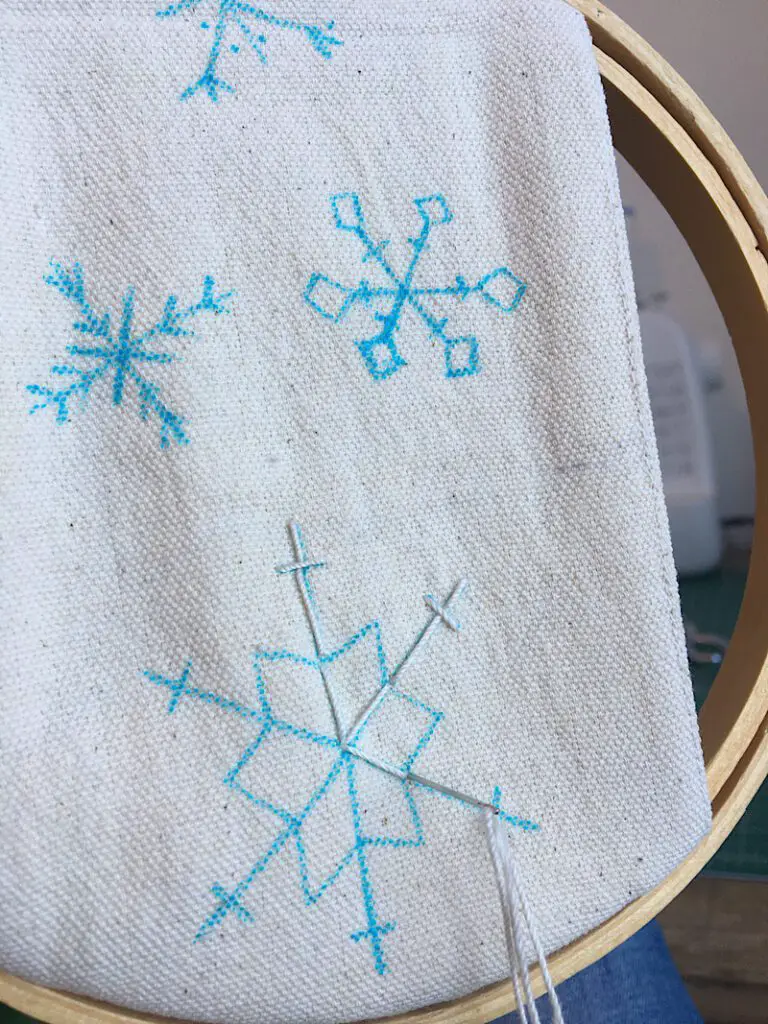 embroidering a snowflake on the door hanger