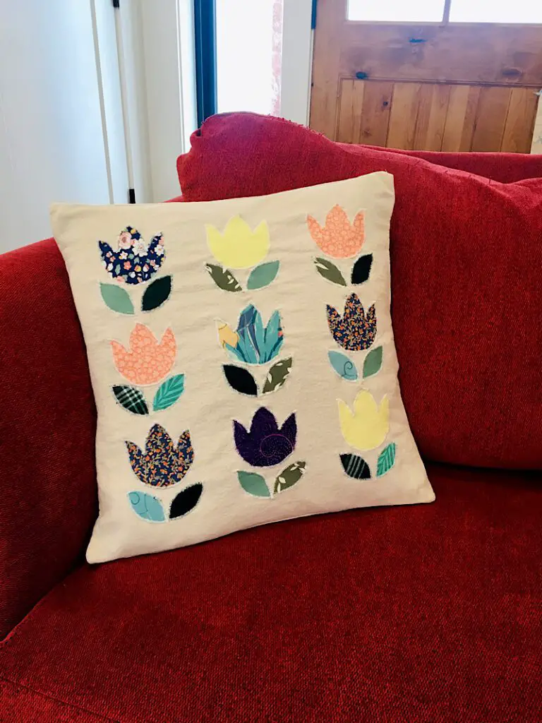 DIY Tulip Pillow Cover applique made from ties on red couch