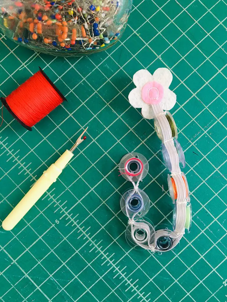 DIY bobbin holder on table with sewing tools