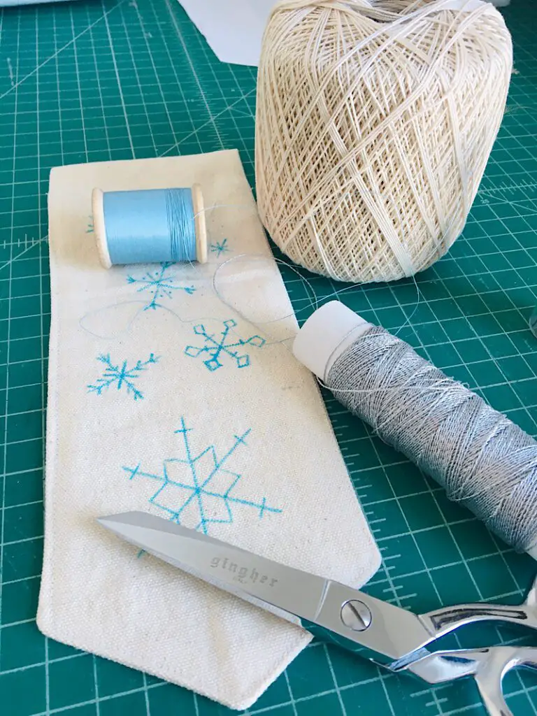 embroidery floss and snowflake banner on table