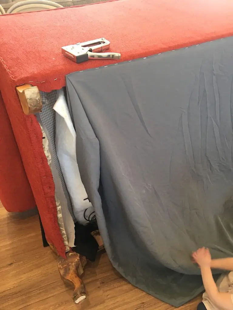 stapling the dust cover to the bottom of the couch
