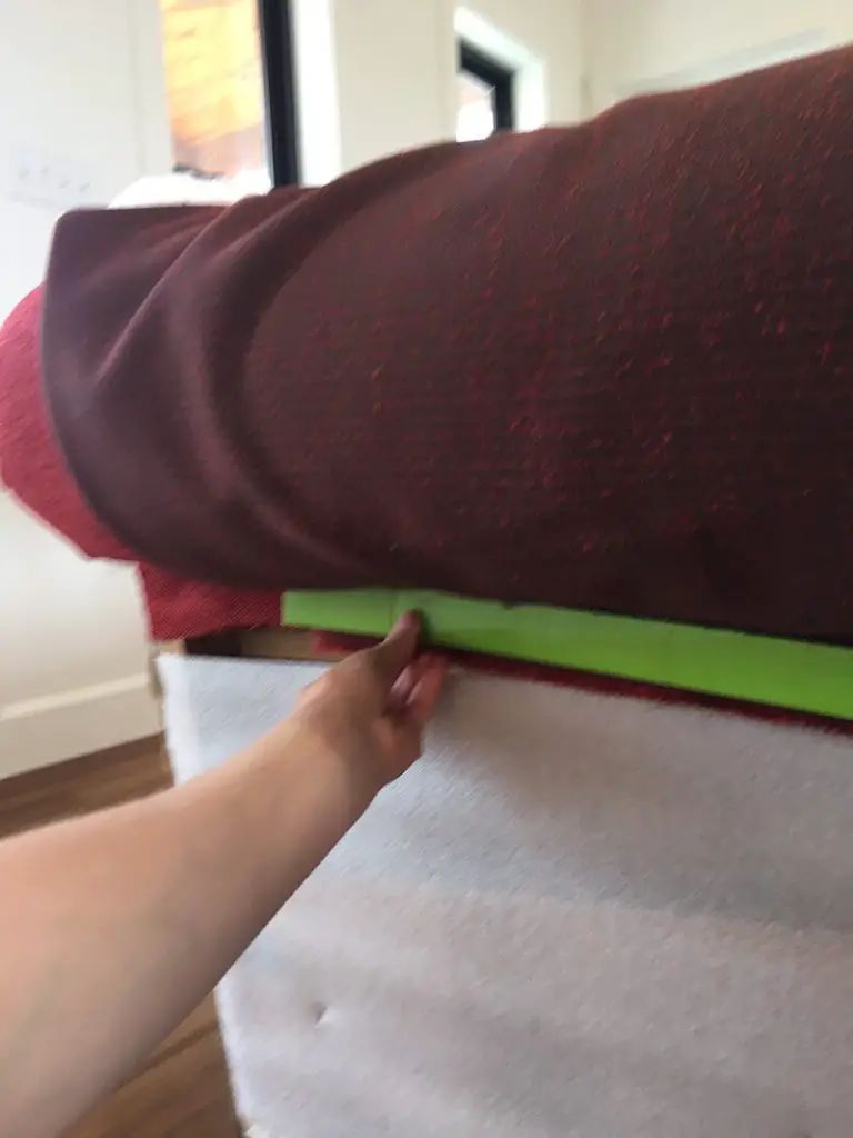 holding the upholstery tack strip up to the couch