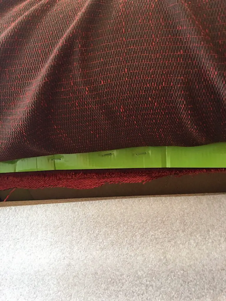 stapled strip of cardboard to side of couch