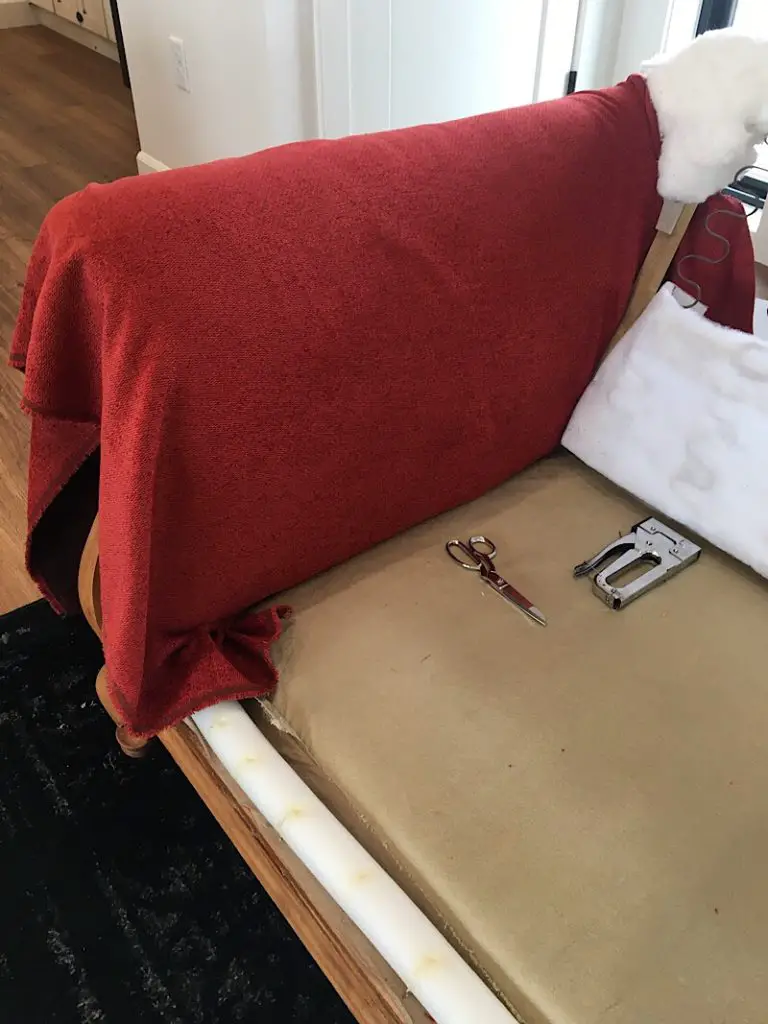 tucking the reupholstery fabric into the arm of the couch