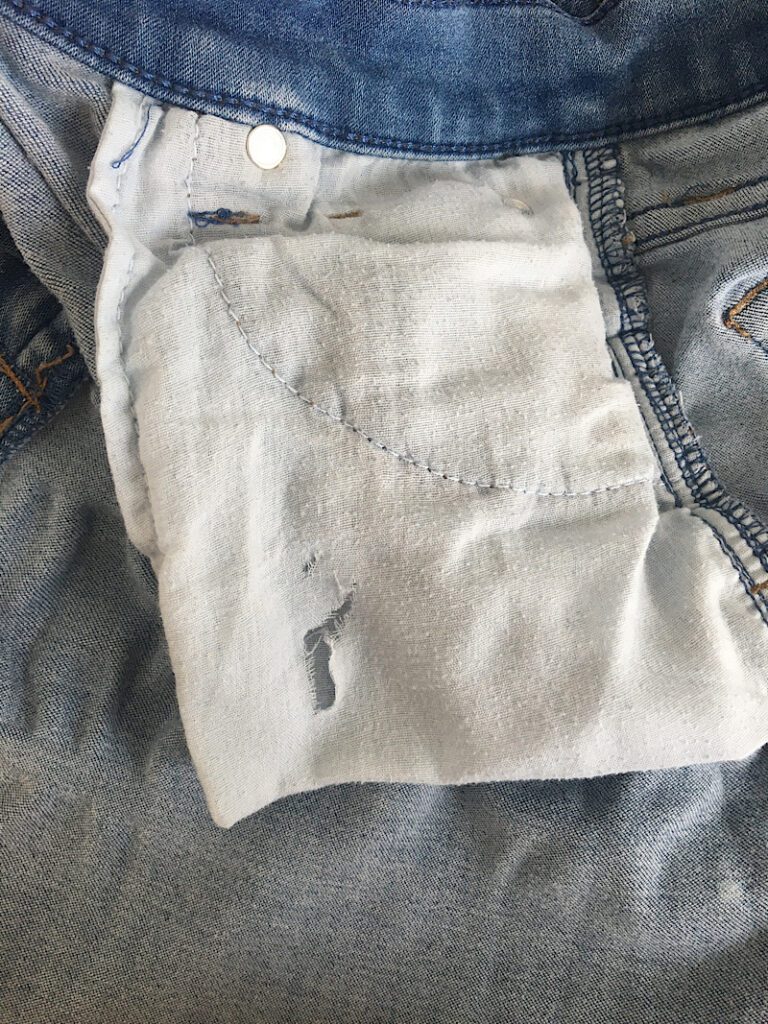 hole in the middle of front pocket jeans