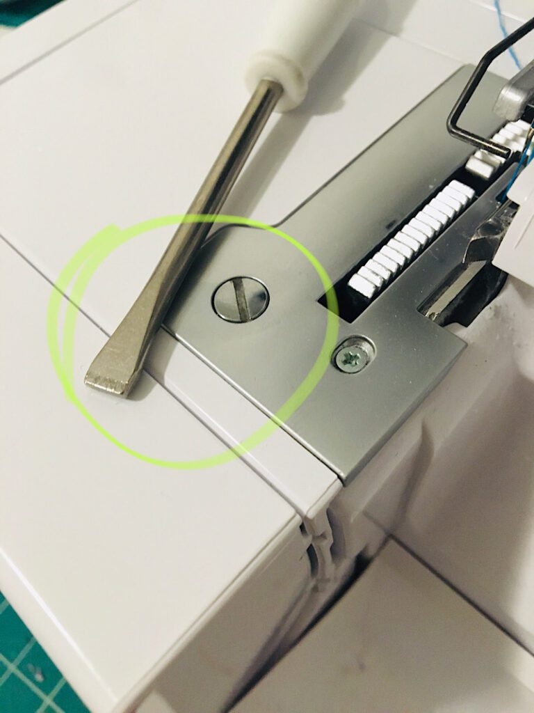 tighten loose screw on serger with screwdriver so needle doesnt break