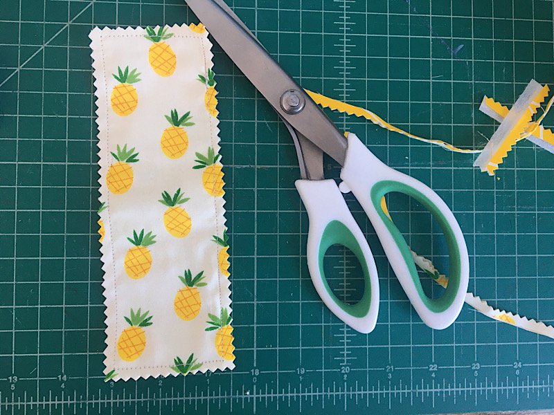 pinking shears cutting around edges of fabric bookmark