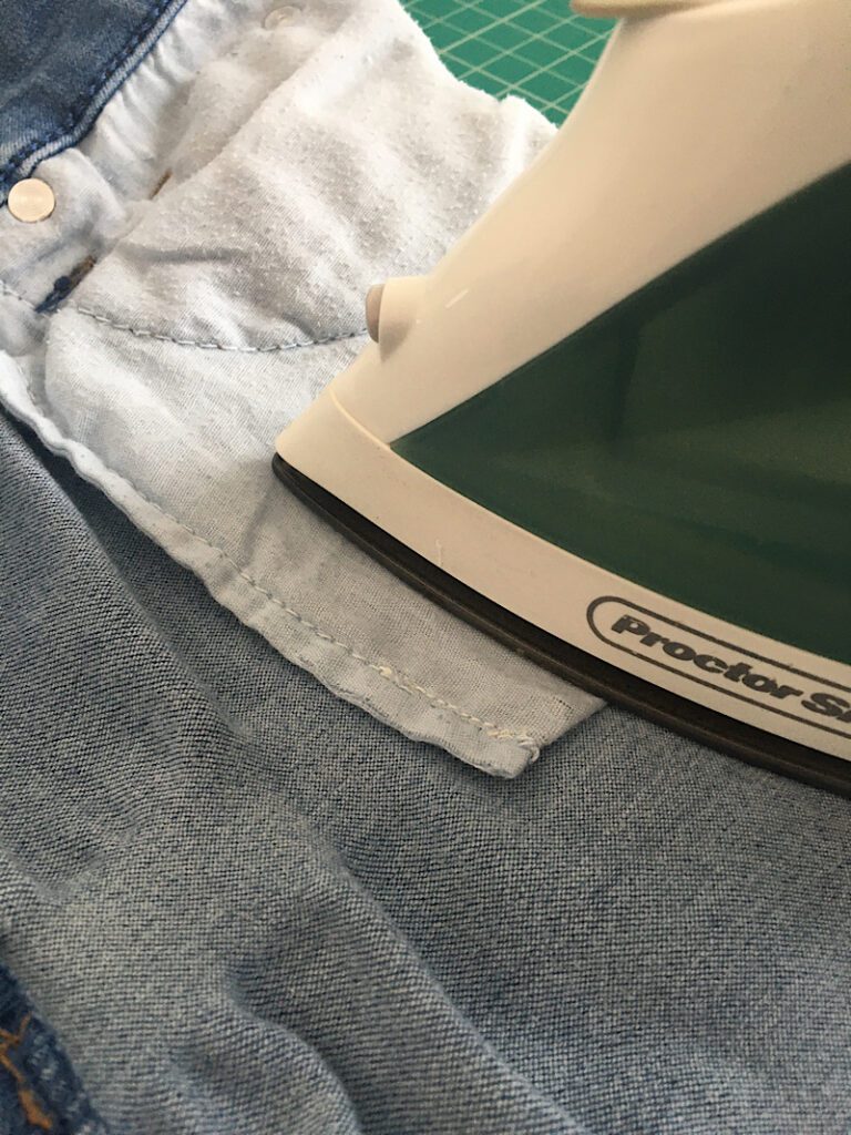 ironing on a patch to fix hole in jeans front pocket
