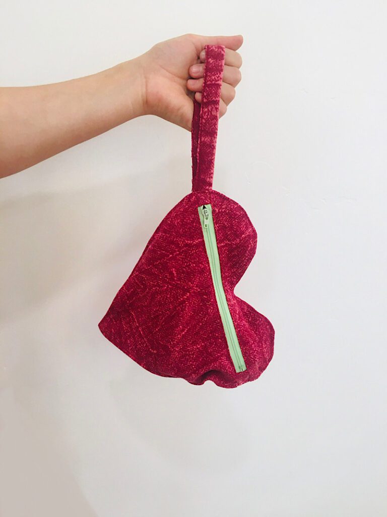 heart shaped clutch with hand holding it