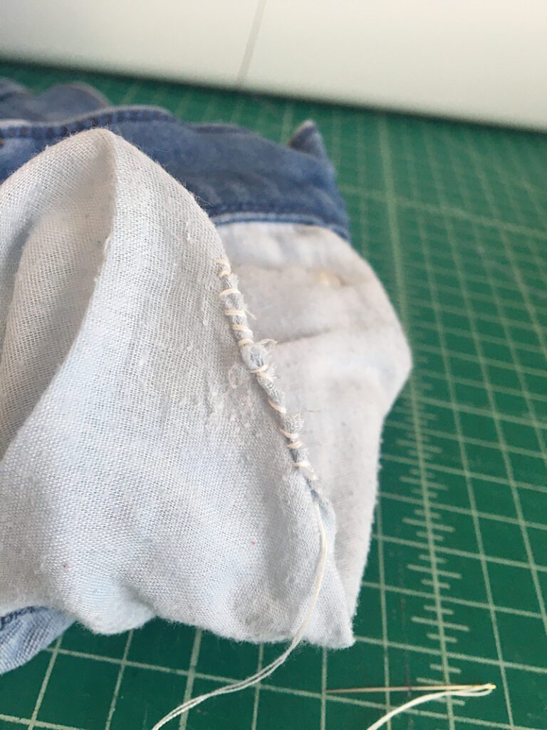 stitches on hole in front jeans pocket