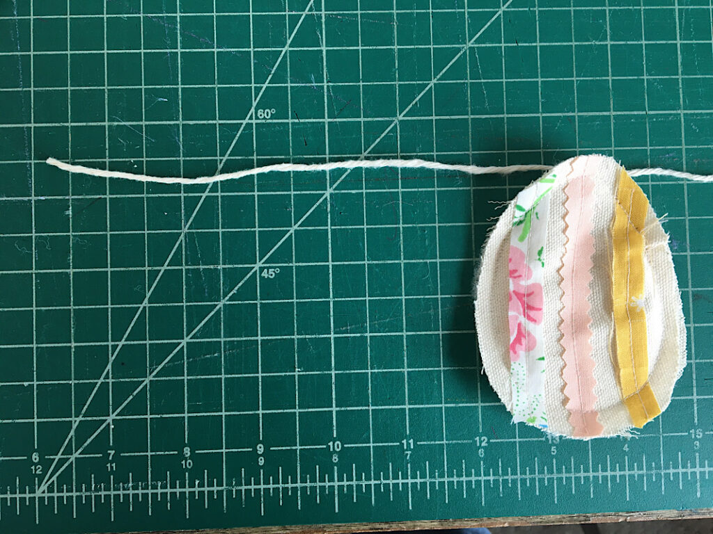 sewing the first fabric egg to the garland