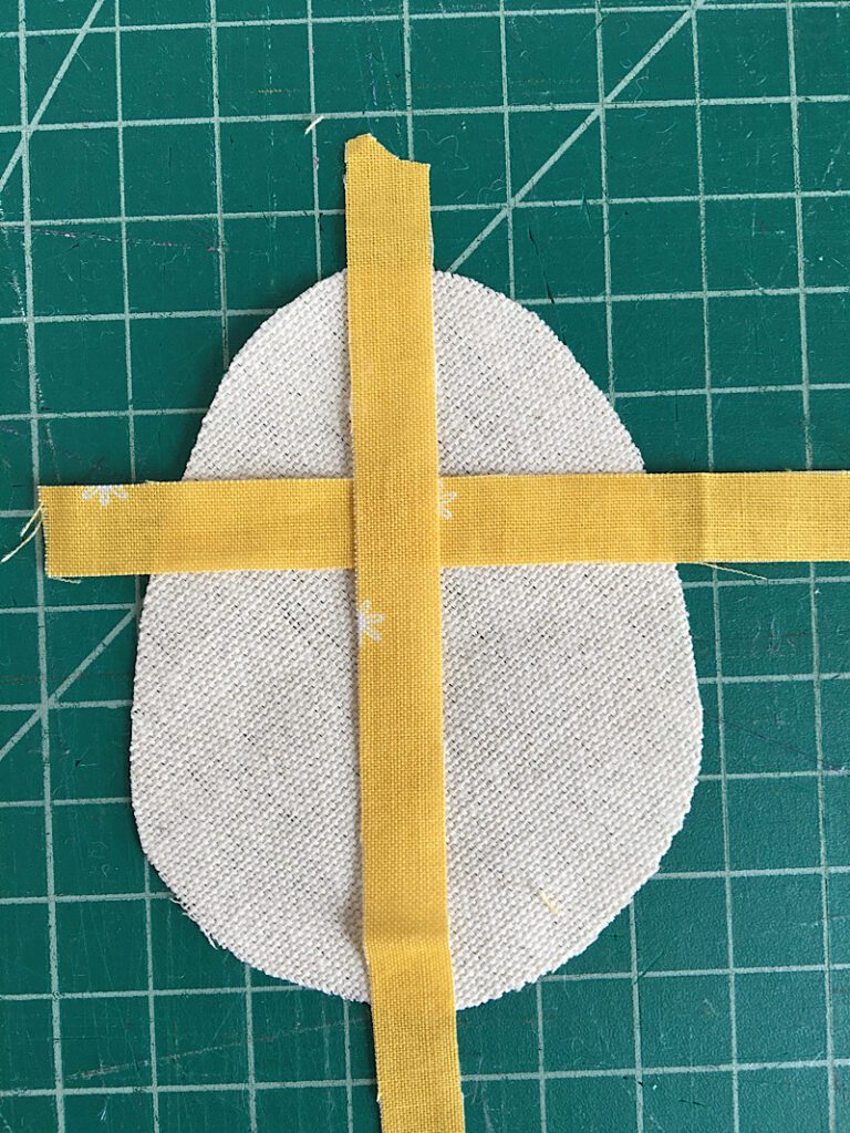 arrange the strips on the egg fabric
