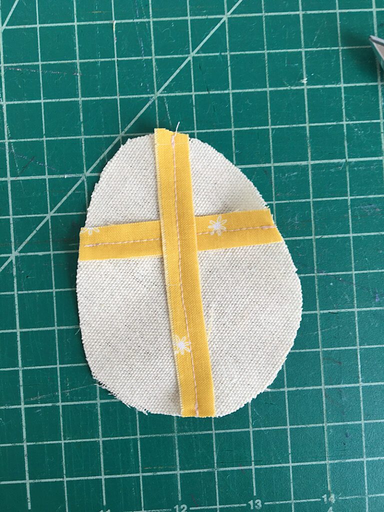 sewing a christian cross on an easter egg