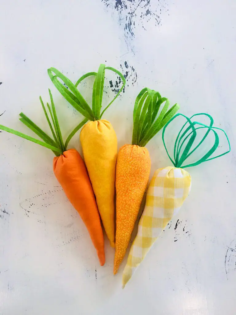 stuffed DIY fabric carrots with different patterns on table