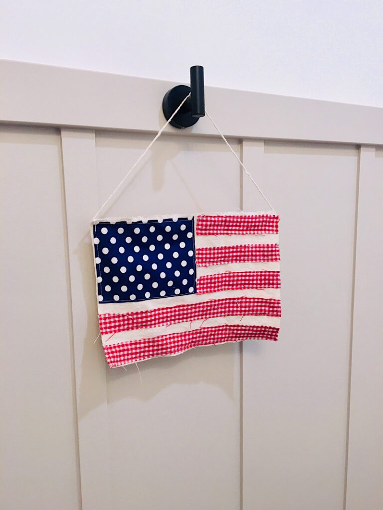 scrappy flag diy sewing project for the fourth of july hanging on a wall hook