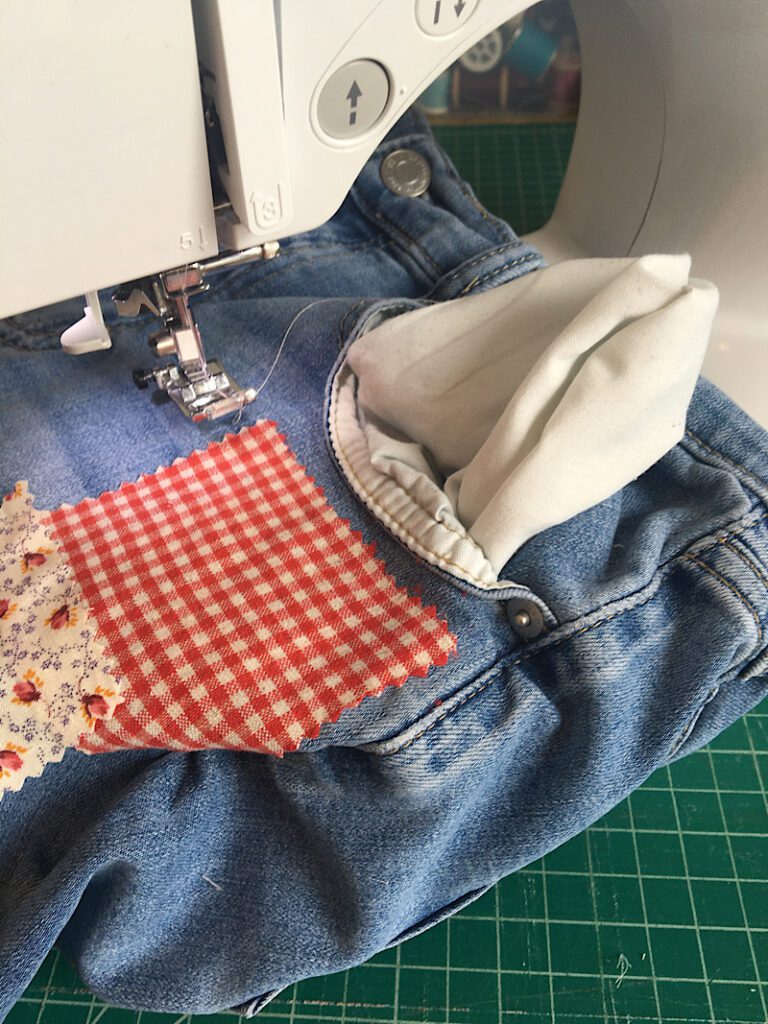 flip the pocket out of the  way when sewing patches onto jeans