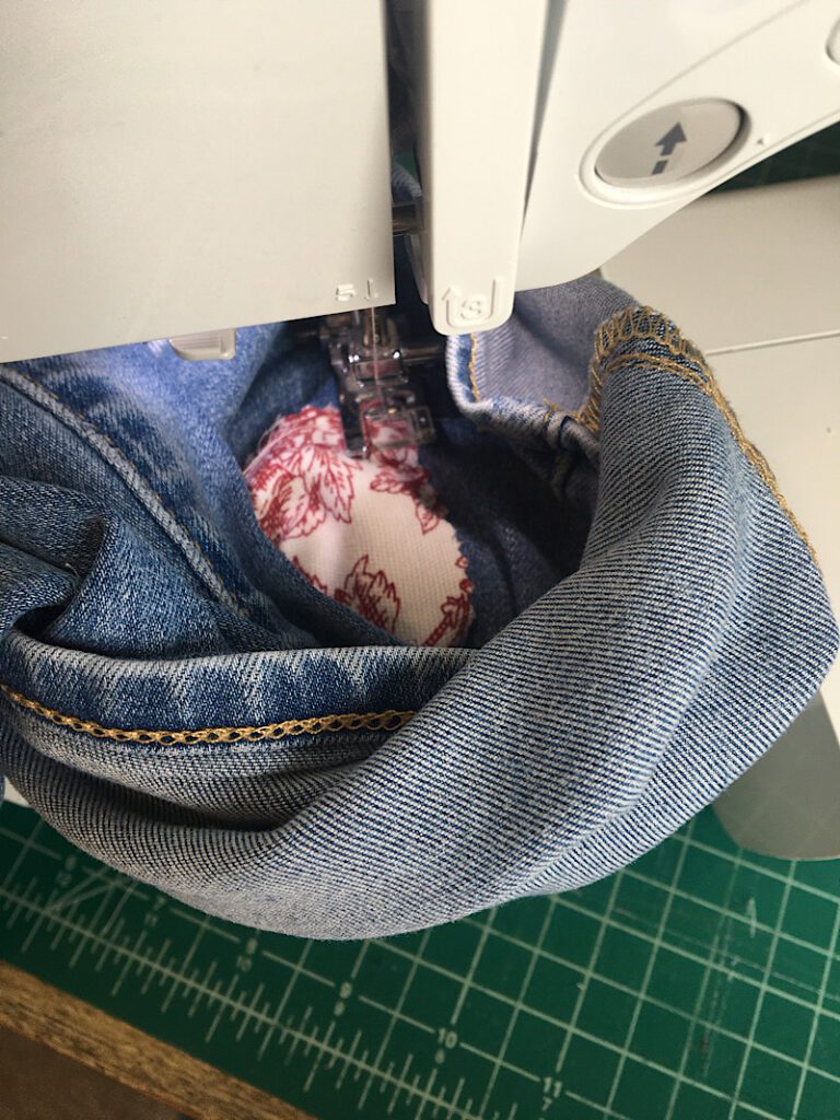 sewing the patches onto the jeans