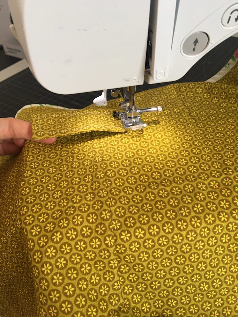 sewing the strap to the waterproof diaper changing mat