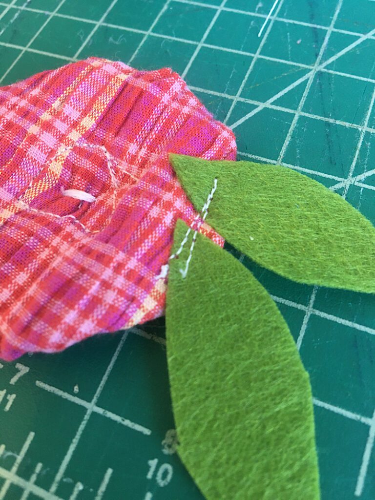 sewing the leaves to the backs of flowers
