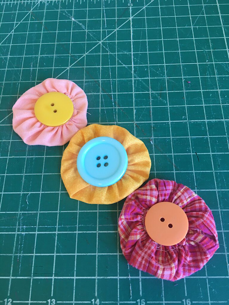 putting a button on the fabric yoyo flowers
