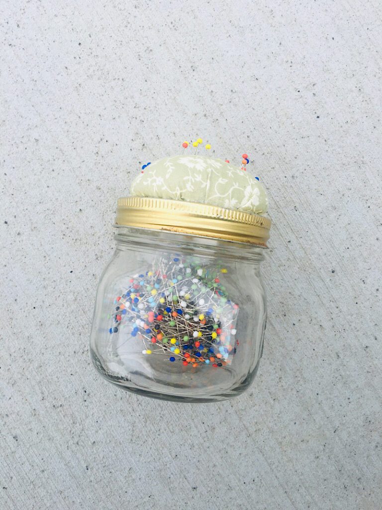 sewing straight pins in a jar with a cushion