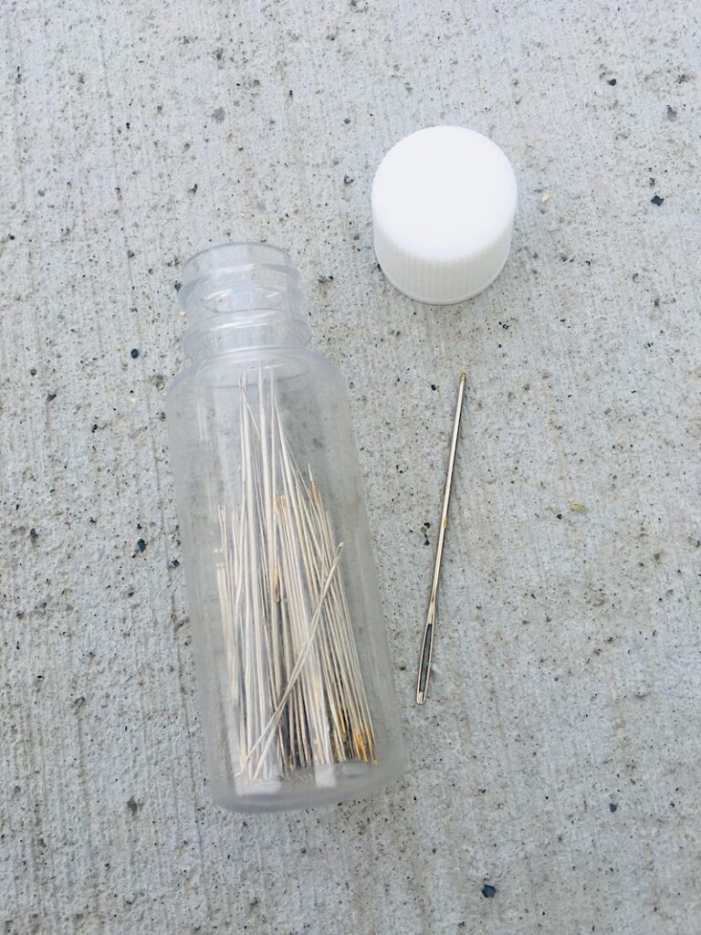Hand sewing needles in a container