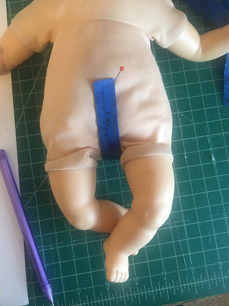 measuring the crotch for doll pants on a doll