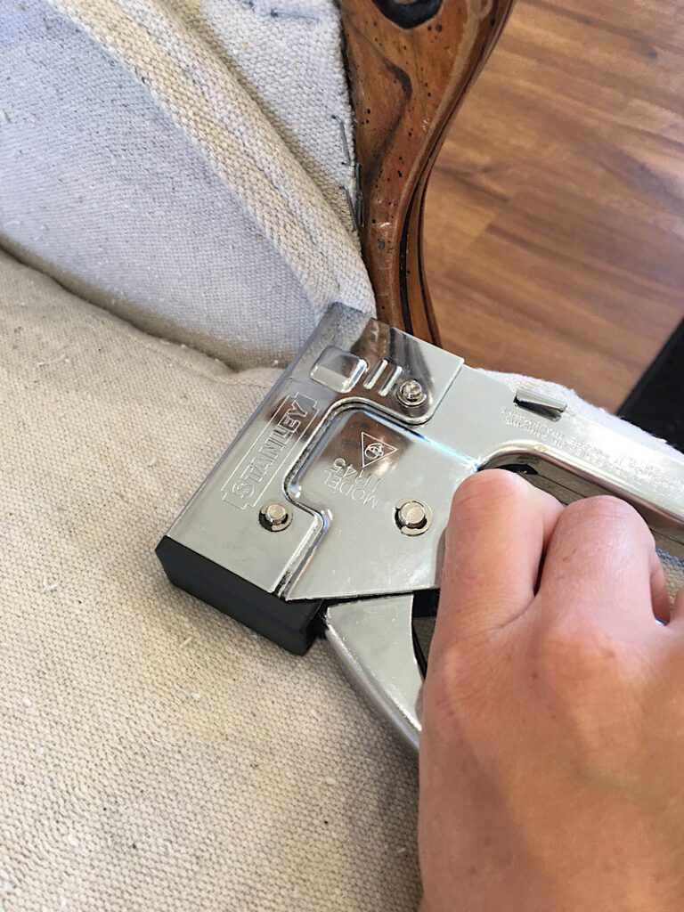attaching double piping to a chair with a staple gun