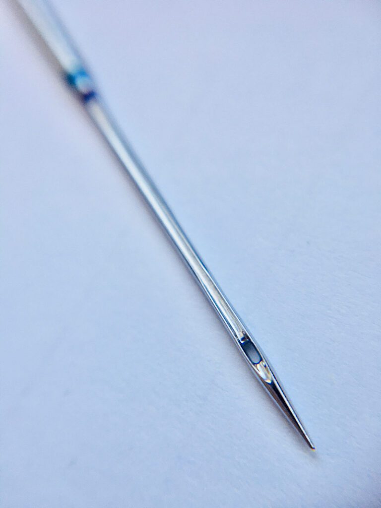 close up macro shot of sewing machine needle