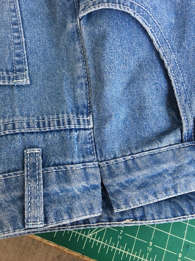 cutting through the waist band of the jeans 