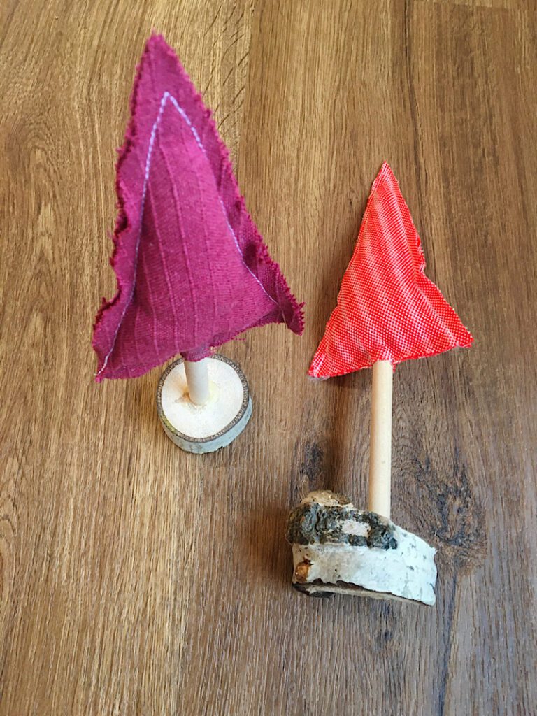 putting fabric christmas trees into log stands